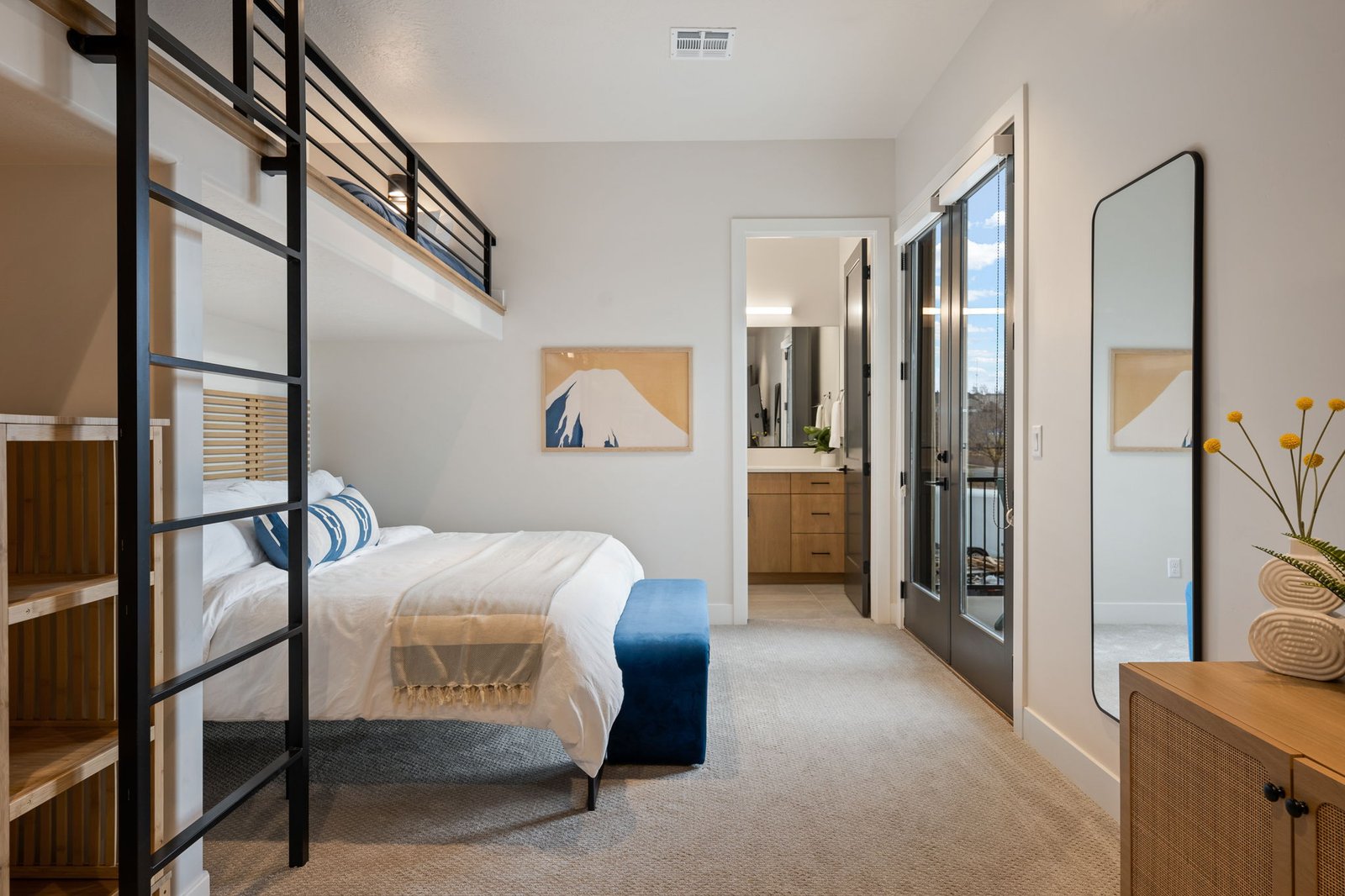 The Loft king bed with the lofted beds overhead and the en-suite bathroom beyond