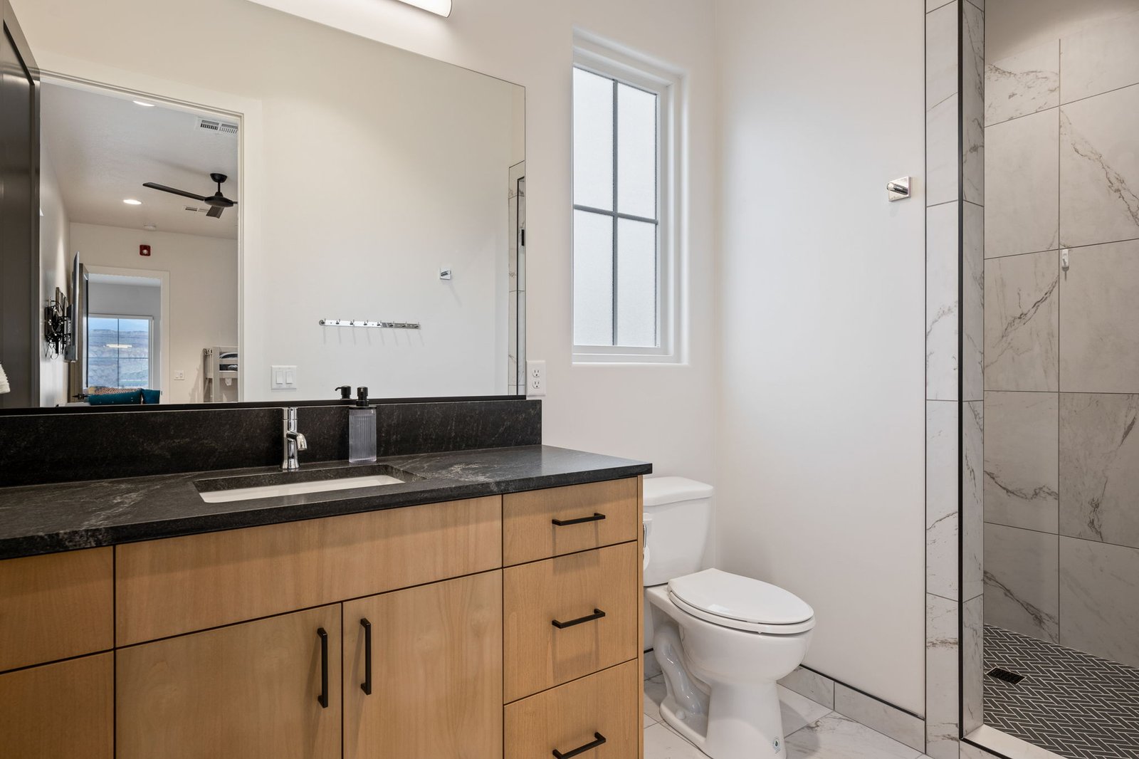 The Bunk Room en-suite bathroom with a walk-in shower and dark stone vanity